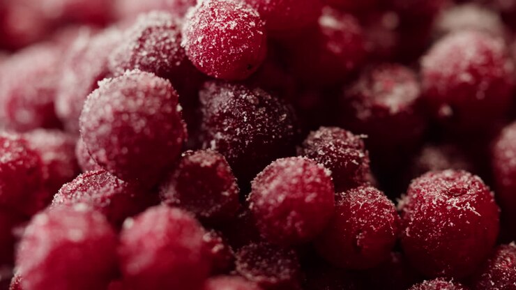 Mirtilli rossi congelati in cottura per tè o marmellata, con un primo piano di bacche di mirtillo rosso in cucina e uno chef che prepara un dolce sano