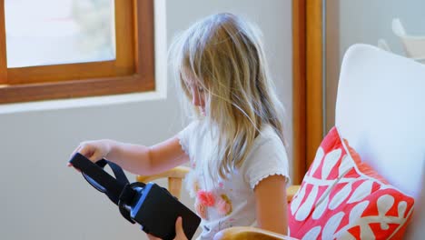 Girl-holding-virtual-realty-headset-in-living-room-4k