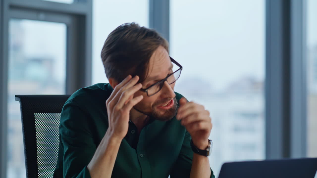 Office worker calling online gesturing to laptop webcam in workplace closeup