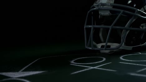 american football head gear on green board with strategy drawing 4k