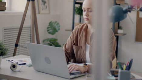 mujer trabajando desde casa en una computadora portátil