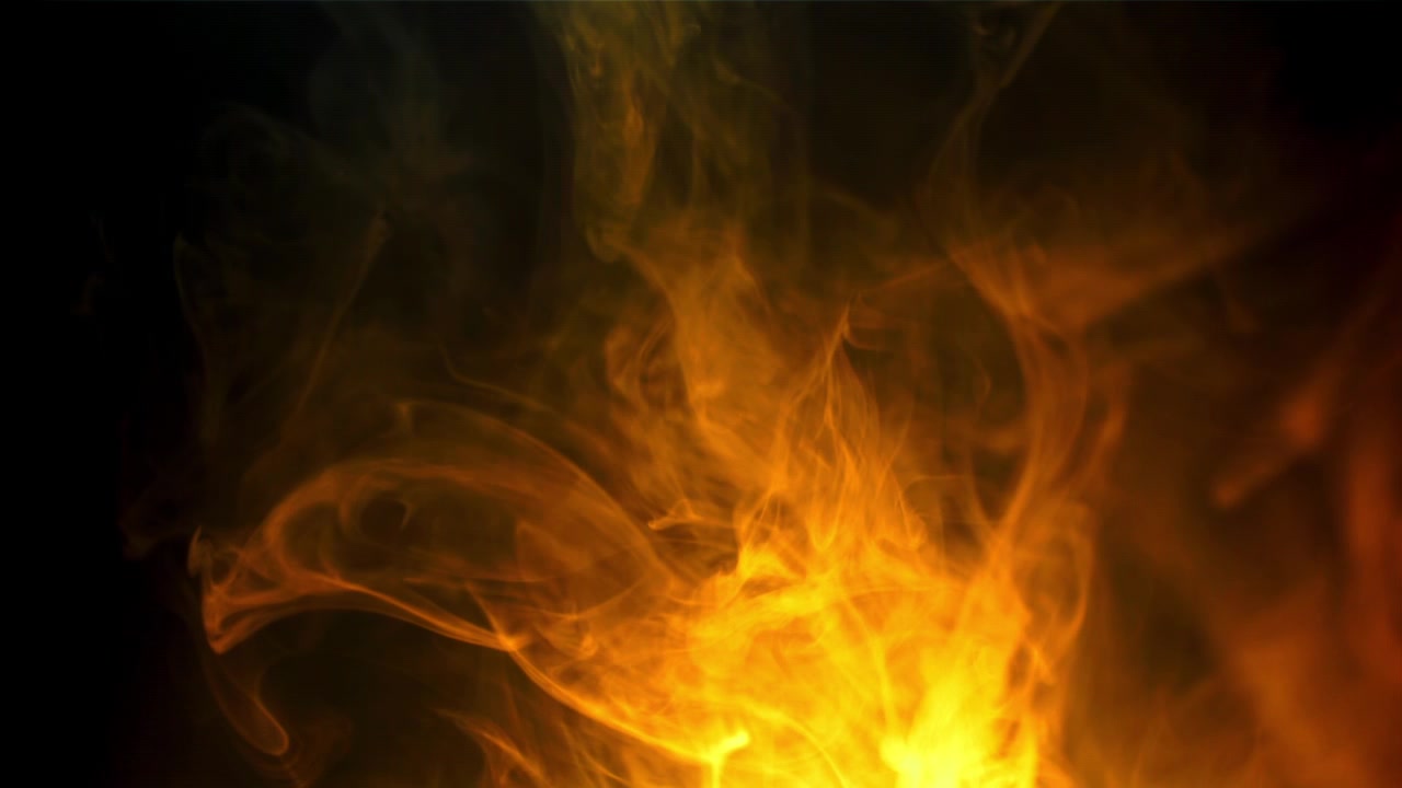 Fumo dinamico arancione e giallo che turbina su sfondo nero