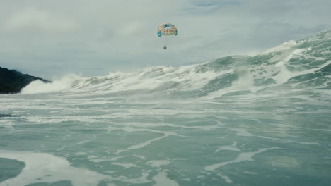 parasailing over a large wave