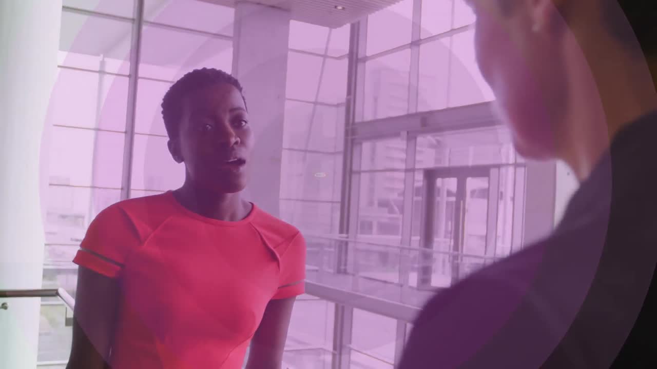 Animation of pink circles pulsating over business people talking in modern office