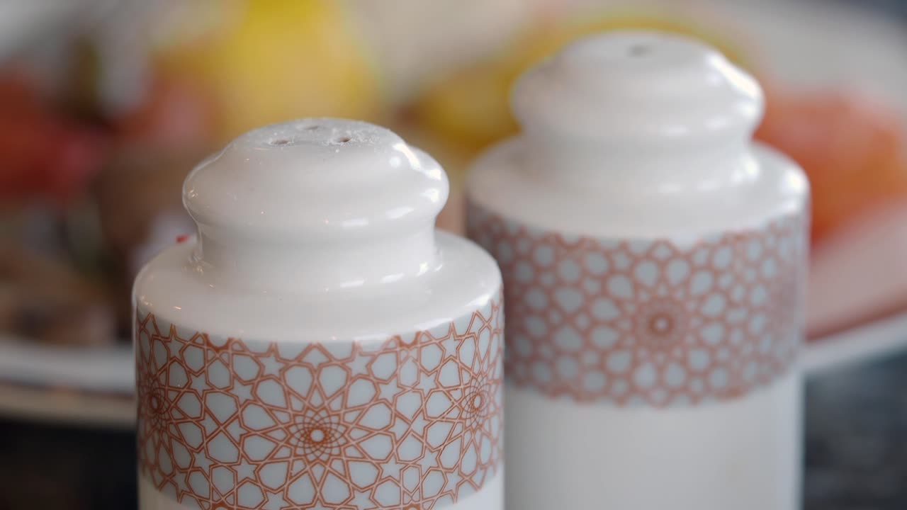 White Ceramic Salt and Pepper Shakers with Decorative Pattern