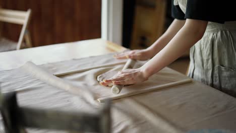 hand working with clay using a rolling pin