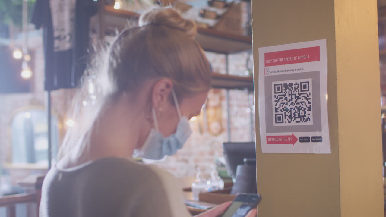 mujer con máscara con teléfono móvil registrándose en el lugar escaneando el código qr durante la pandemia de salud