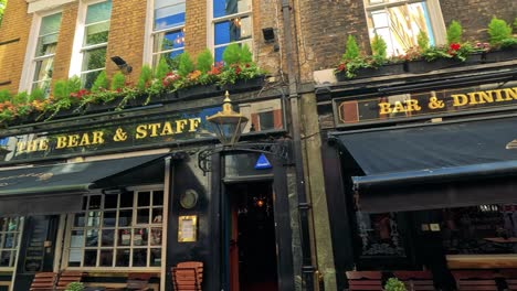 people walking past a pub in london