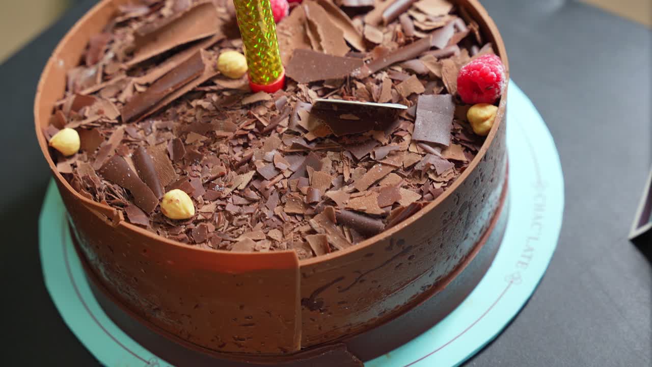Decorated chocolate cake with raspberries and candle—perfect for celebrations, birthdays, or festive food visuals
