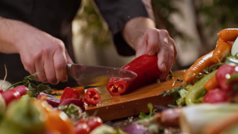 chef cortando pimientos y verduras rojas