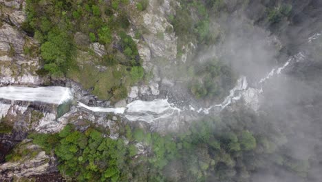 aerial top down view of a powerful waterfall cascading through rocks and pine trees - valle d'aosta, gressoney-saint-jean