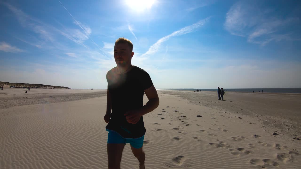 hombre corriendo en la arena a la orilla del mar, cámara lenta