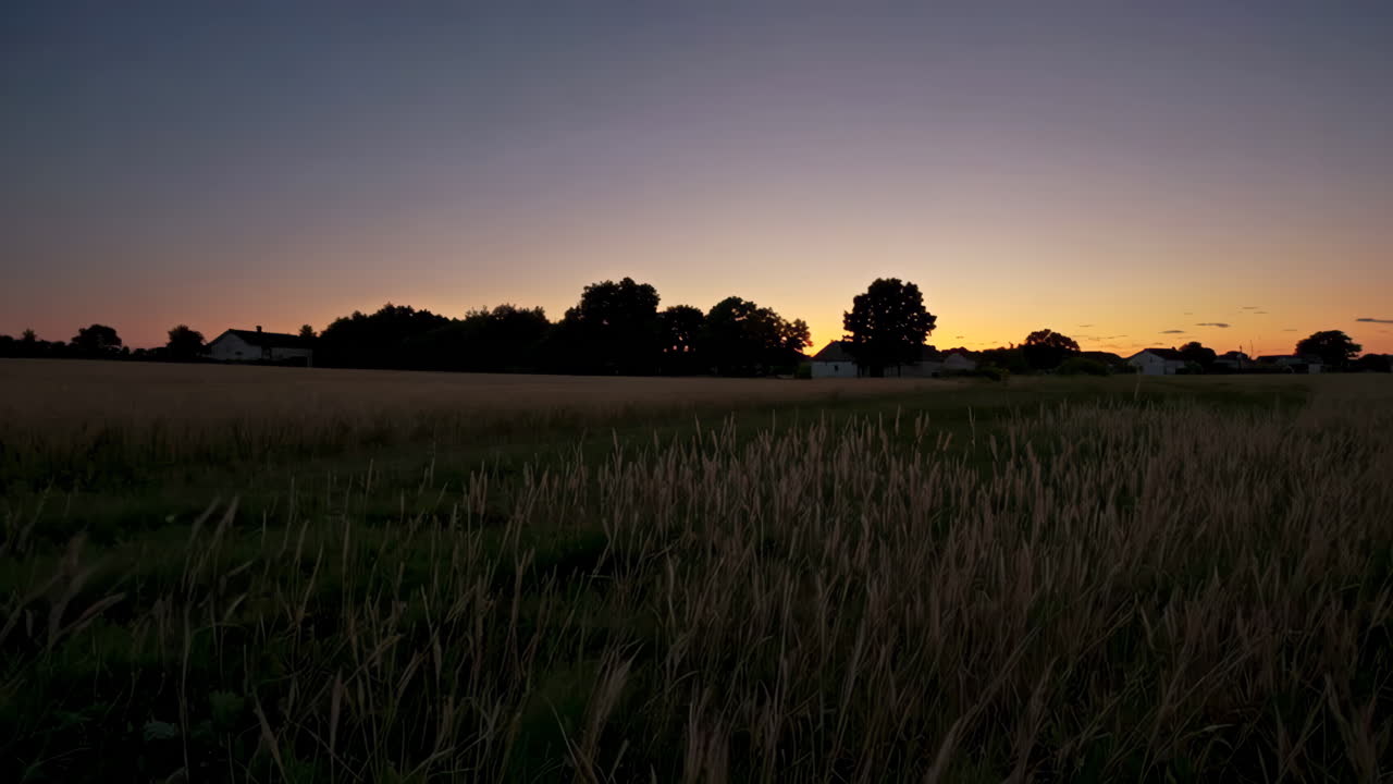 Solnedgang over et landlig jorde