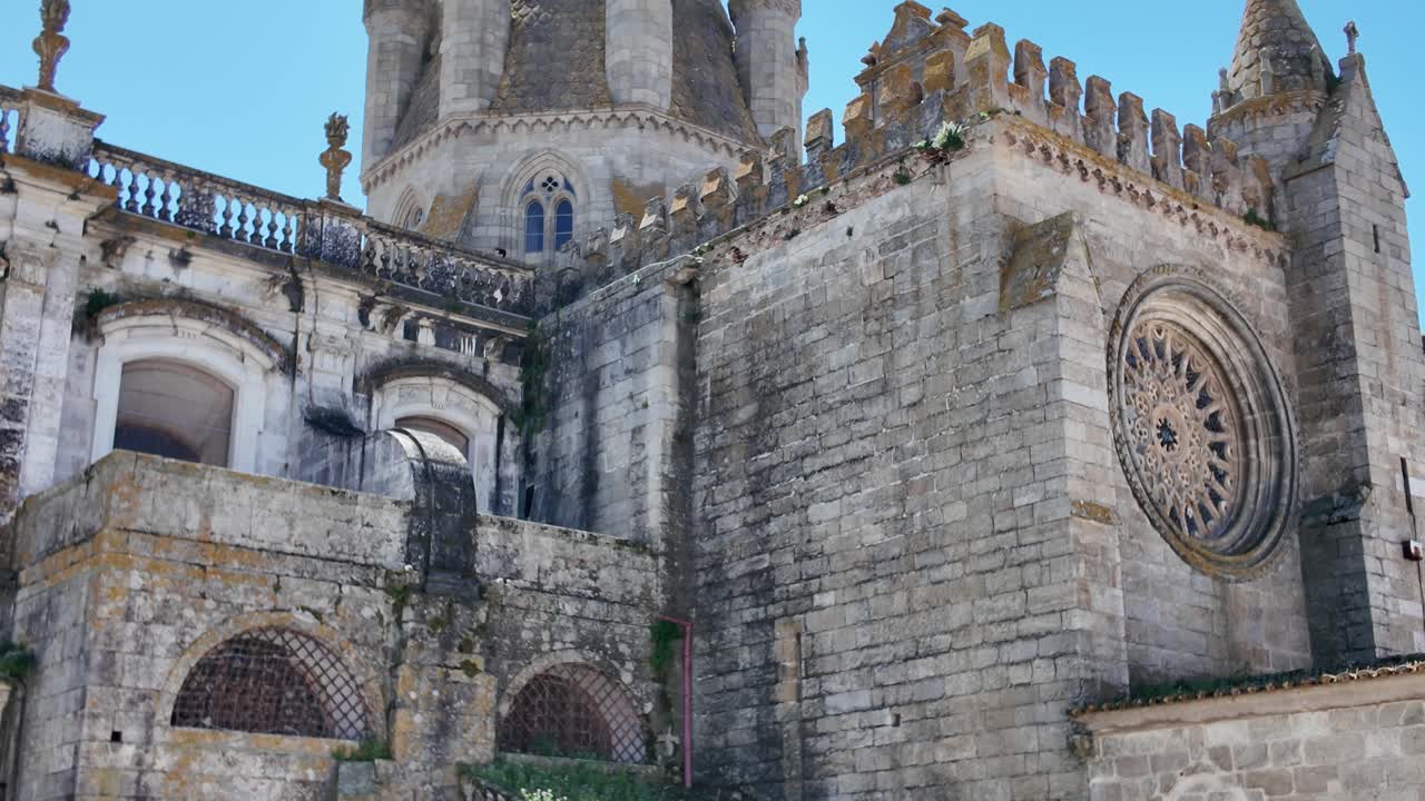 Exterior detail of the Cathedral of Évora featuring Gothic rose window and medieval stone walls