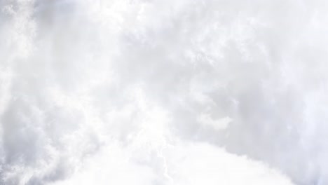 a thunderstorm that blazed inside the dark cumulus cloud against a white cloud foreground