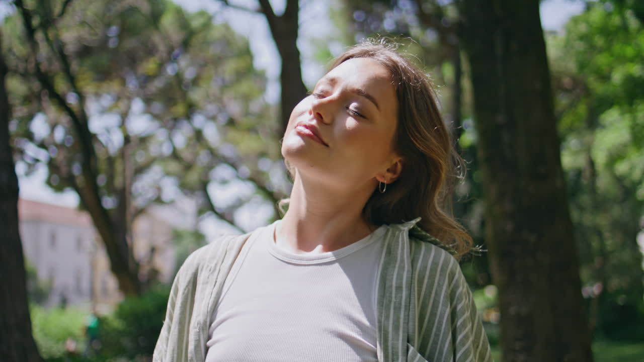 Carefree girl basking sunlight closing eyes at nature closeup. woman
