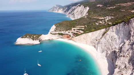 Luftdrohnenansicht-Des-Strandes-Von-Porto-Katsiki,-Der-Ionischen-Insel-Lefkada,-Griechenland---Steile-Felsklippen,-Segelboote,-Küstenlinie-Und-Türkisblaues-Meer