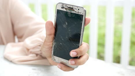 women holding broken smart phone,