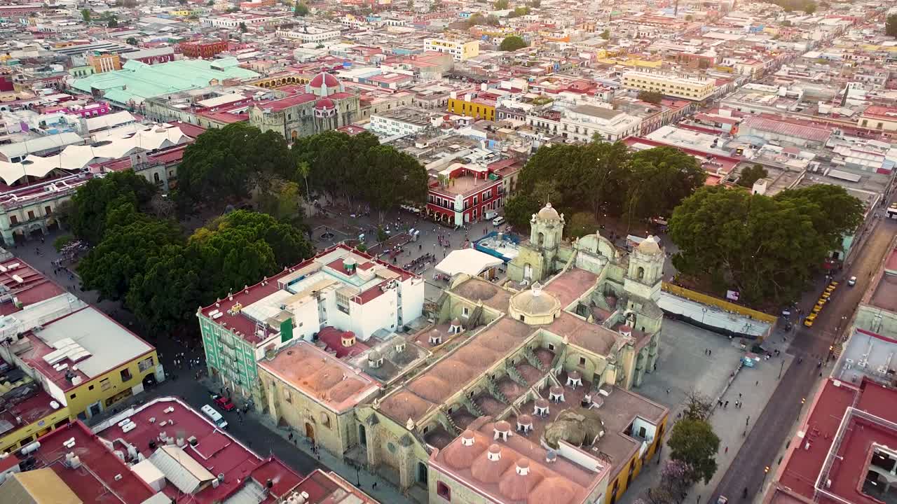 Aerial flyover beautiful city of Oaxaca de Ju&aacute;rez with park, historic old town and cathedral - tilt down
