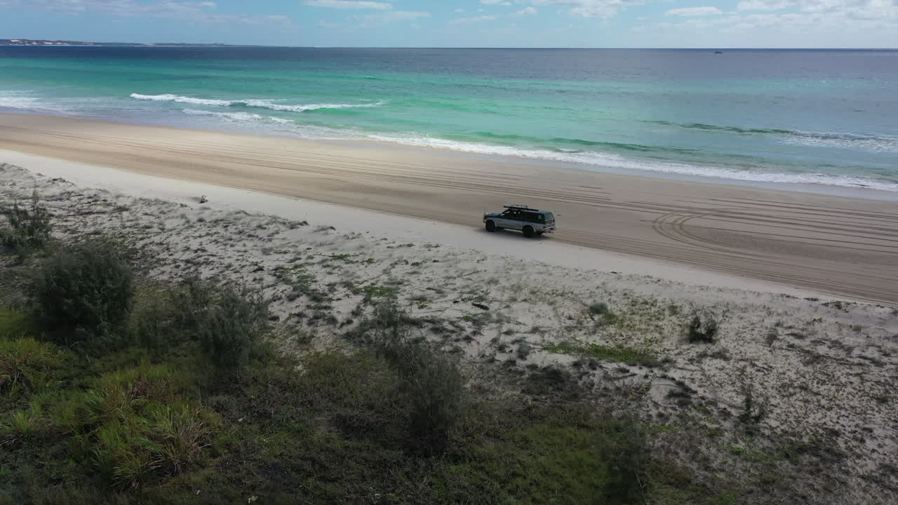 광대 한 호주 모래 해변에서 운전하는 공중 천천히 궤도를 도는 트럭