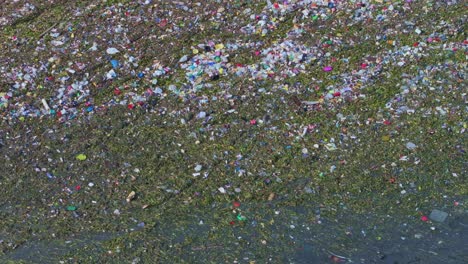 Aerial-top-down-shot-of-garbage,waste-and-plastic-swimming-on-water-surface-of-ocean