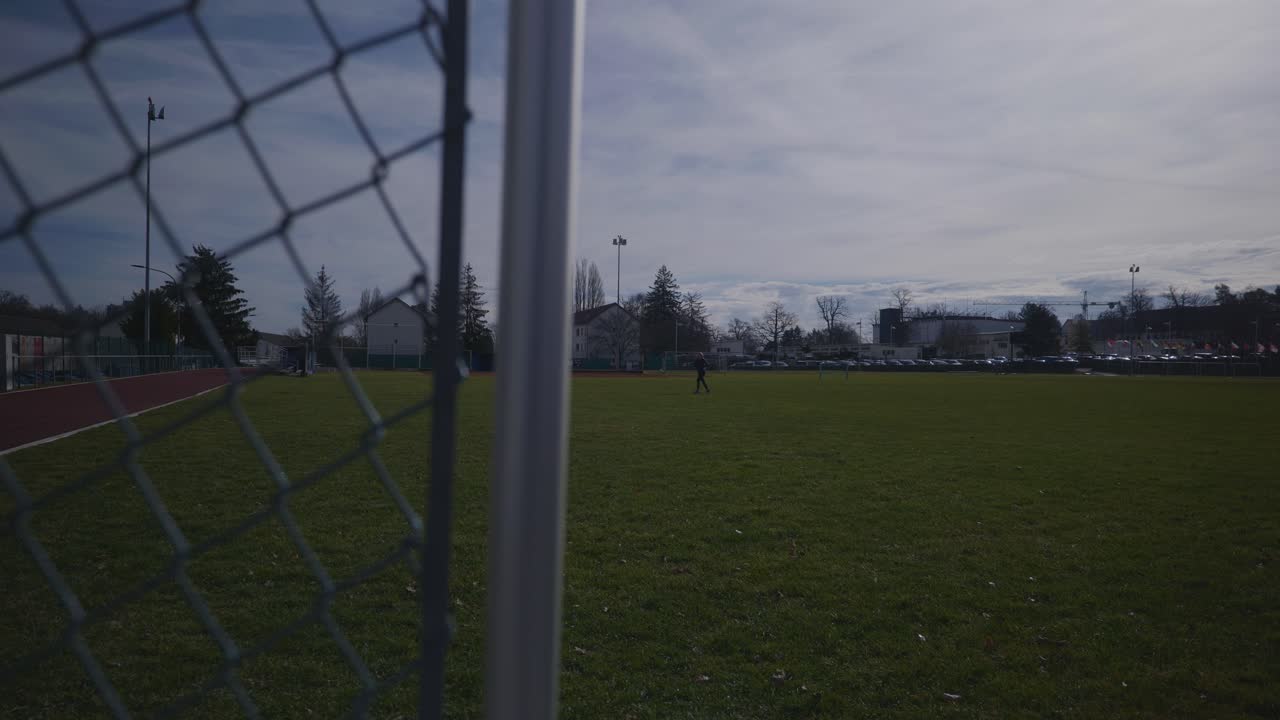 Female Running In The Distance of Empty Sports Complex Field In 4K