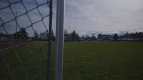 female running in the distance of empty sports complex field in 4k