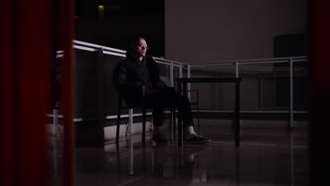 man sitting on a balcony at night