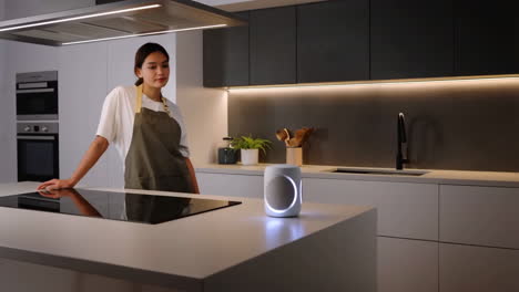 woman in a modern kitchen with a smart speaker