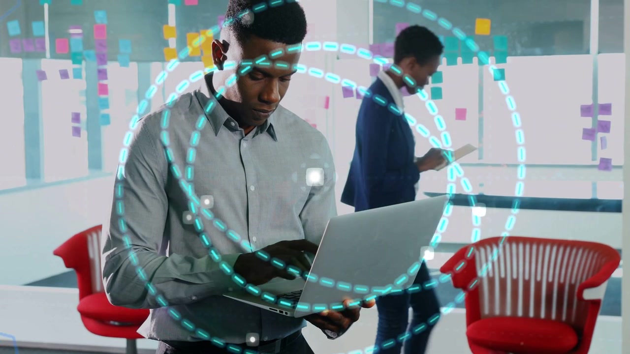 Male pro while typing laptop in office, animated teal rings appearing showing live data for team