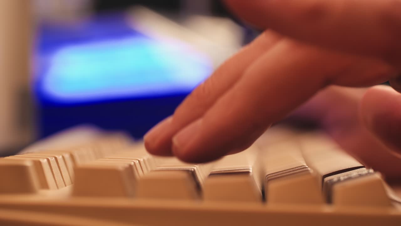 Man working and gaming on retro computer PC, IT engineer with vintage computer at home, using old fashion technology, close up of retro setup.
