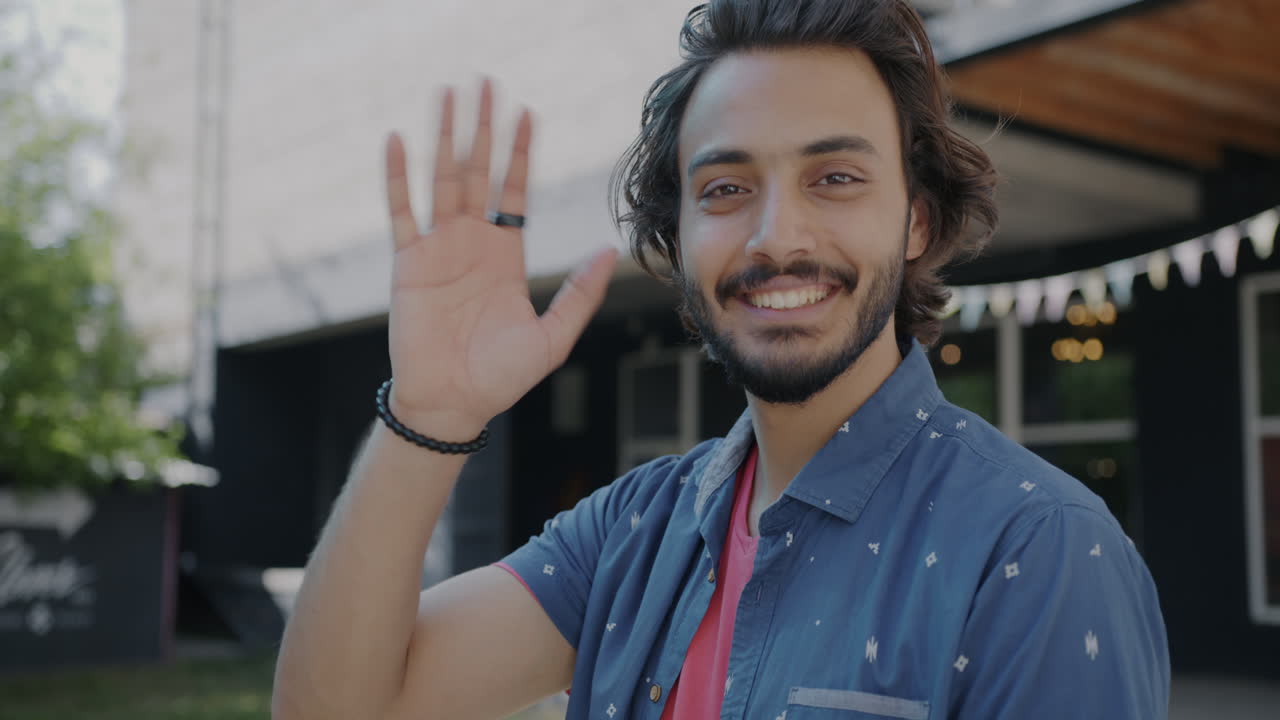 Man waving happily outdoors