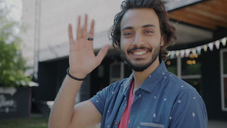 man waving happily outdoors