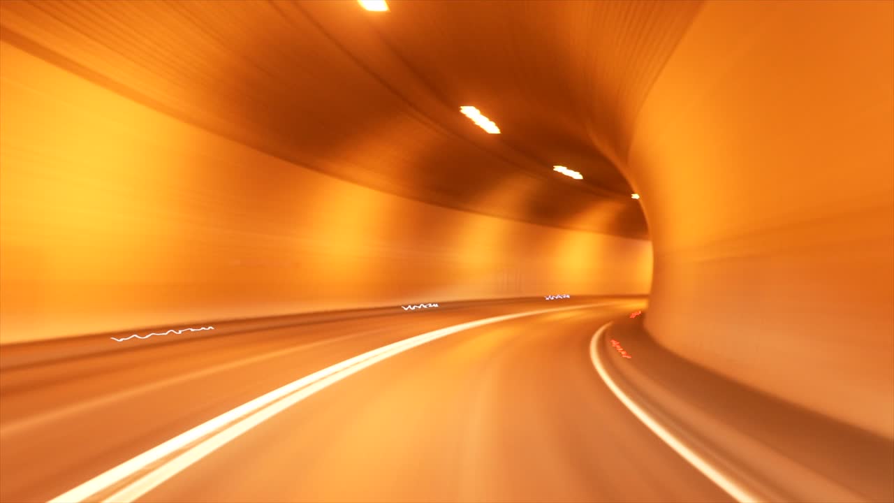 Timelapse shot driving through tunnel with intense orange lighting.