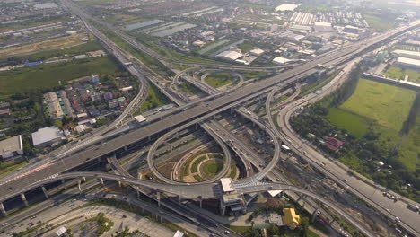 aerial view of highway road interchange with busy urban traffic speeding on road