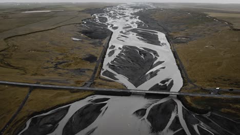 Ring-road-Iceland,-aerial-car-driving-over-bridge,-glacial-river-flying-over-nature-ocean-scenery-view