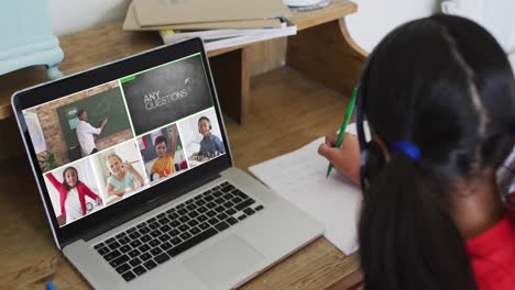 Schoolgirl-using-laptop-for-online-lesson-at-home,-with-diverse-teacher-and-class-on-screen