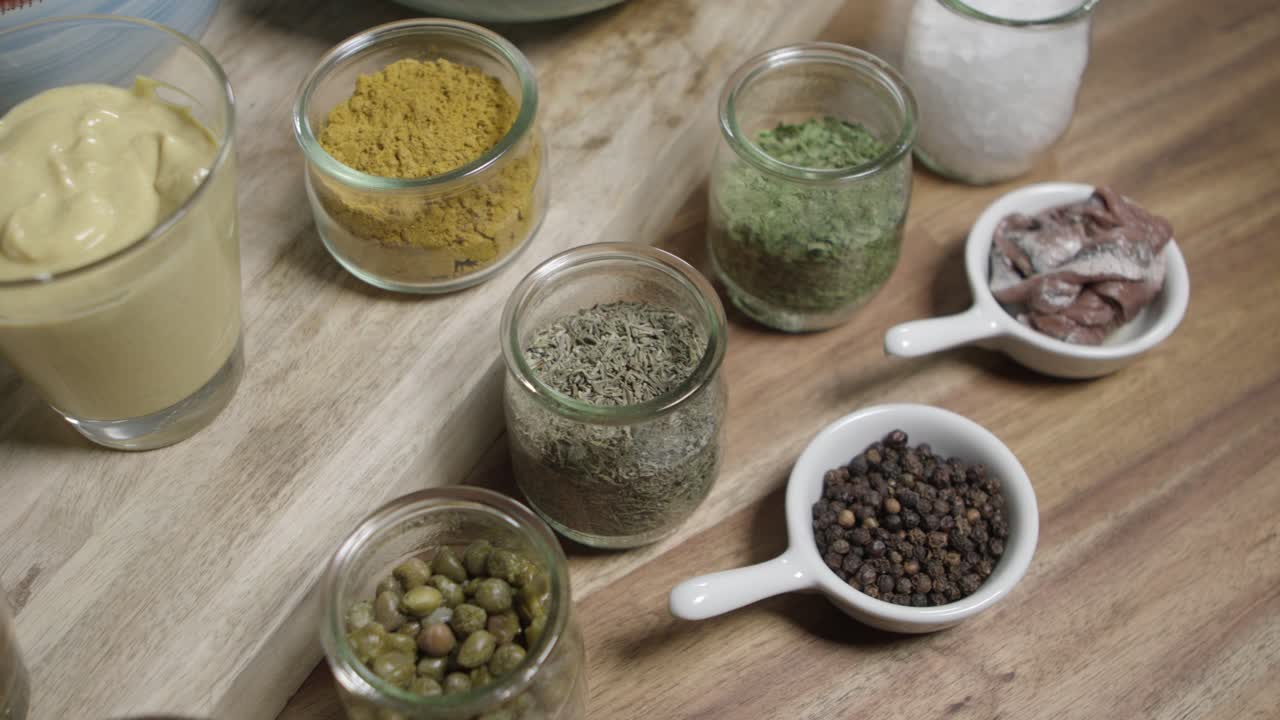 Moving top view shot of lined up ingredients for the legendary caf&eacute;-de-paris butter