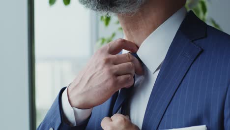 man adjusting tie