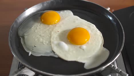 chef rompiendo el huevo en una sartén caliente para cocinar