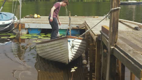 young man bailing water from a fiberglass row boat