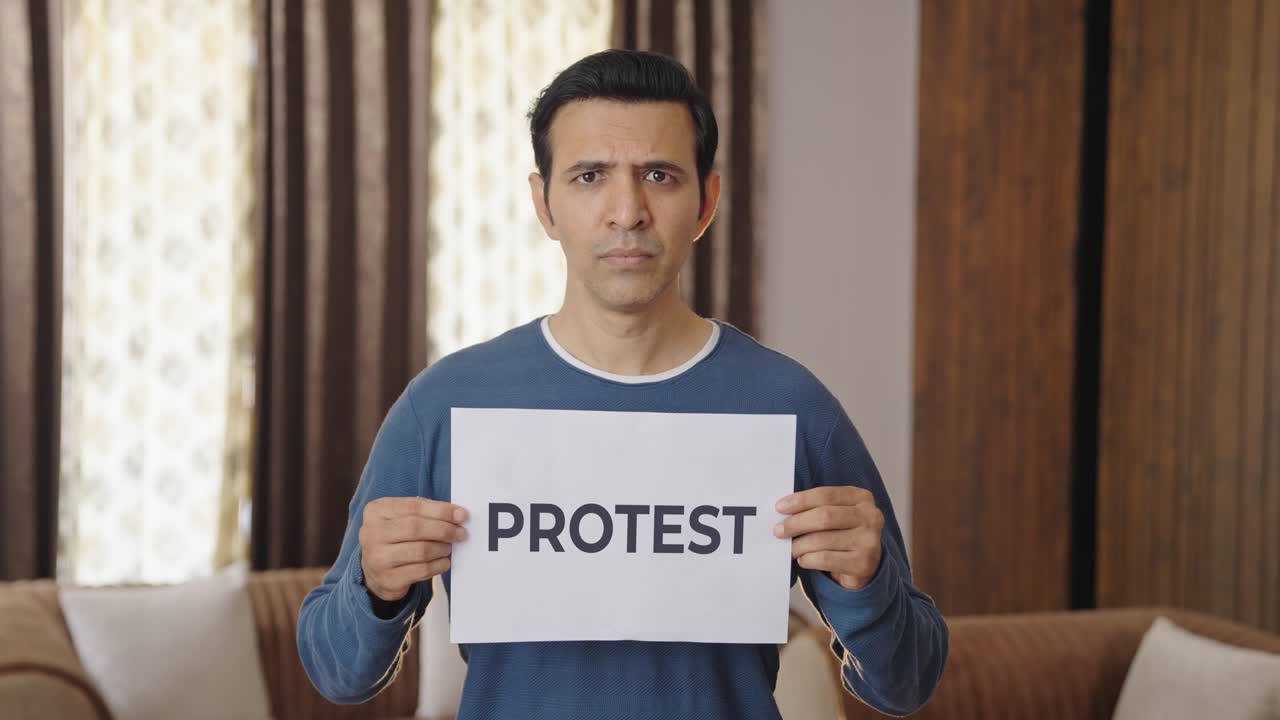 Pria India marah memegang spanduk PROTES.