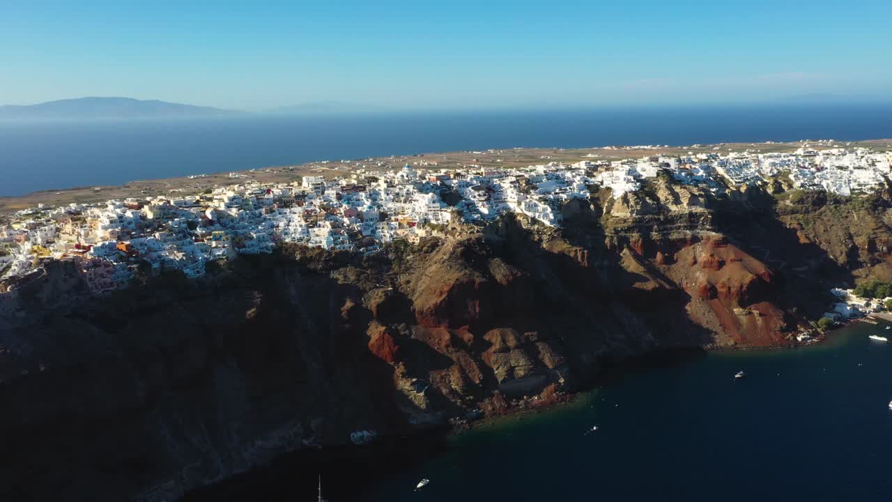 Aerial wide view of famous greek village Oia with white cave houses and villas in Santorini, Greece.