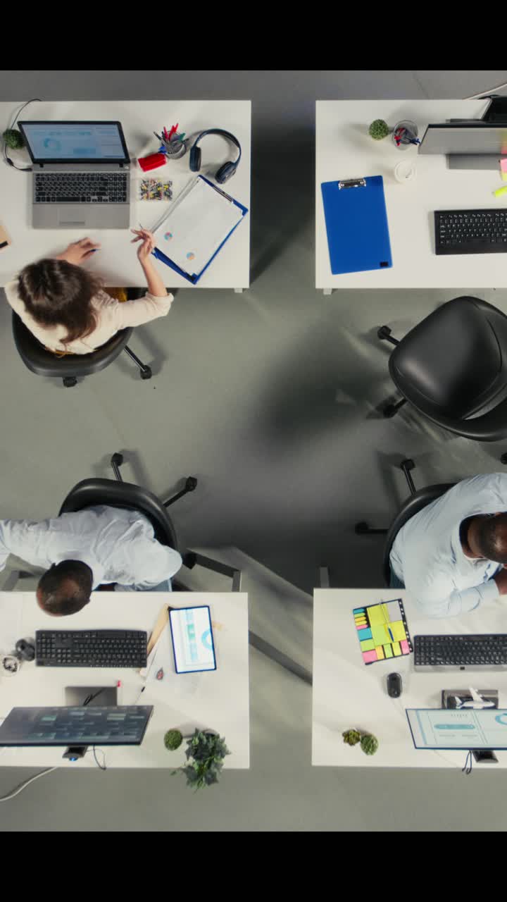 Vertical Video Top down view of professional coworkers engaged in report sharing