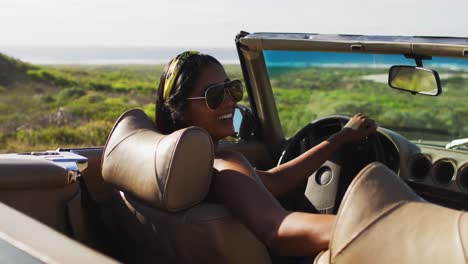 Portrait-of-african-american-woman-sitting-in-the-convertible-car-on-road