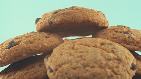 un primer plano macro de un plato blanco lleno de galletas con chispas de chocolate, en un soporte giratorio 360, iluminación de estudio, cámara lenta, video de 4k