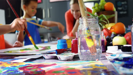 teacher assisting schoolkid in drawing class