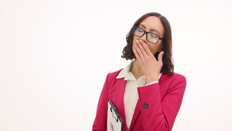 Woman in pink blazer yawning while holding a folder