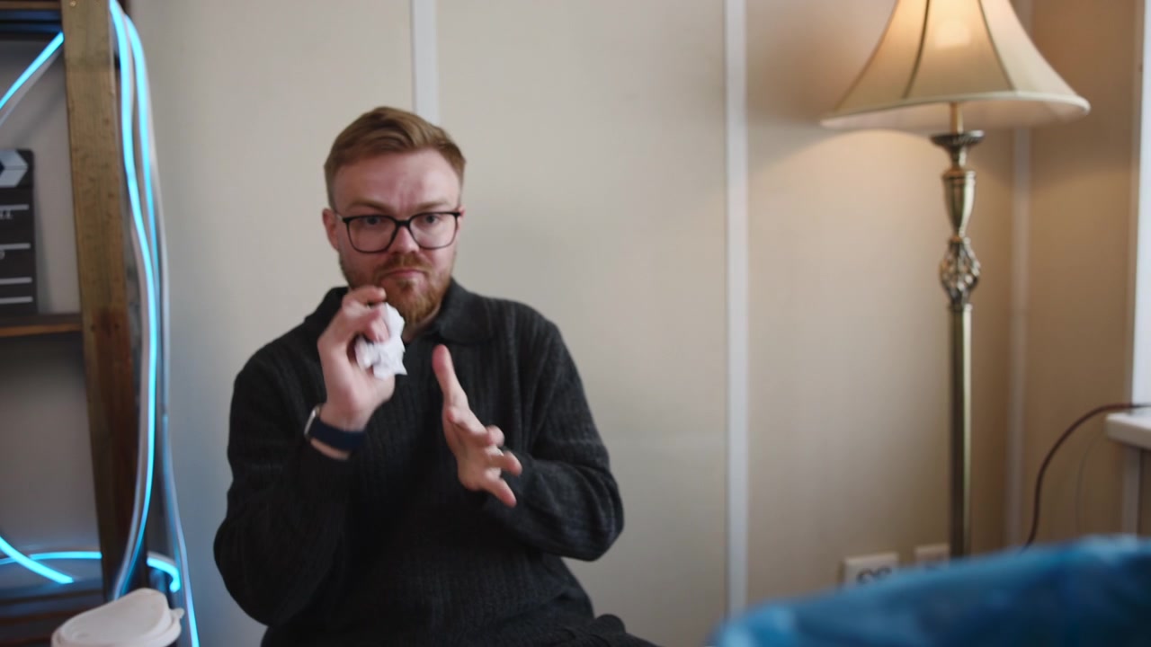 Uomo bianco che spacchetta un gadget in un ufficio domestico, recensore di prodotti ispeziona una nuova periferica con espressione perplessa.