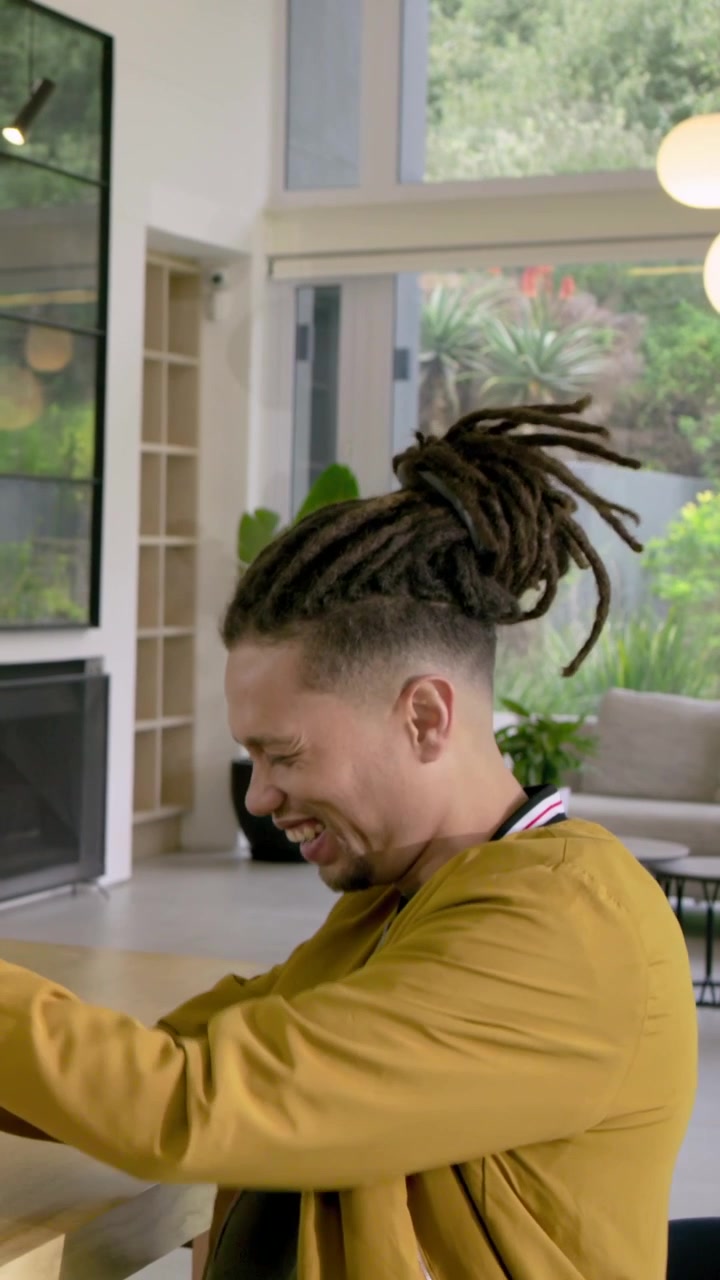 Vertical video: Leaning woman passing salad bowl, man in mustard jacket reaching, laughing at table